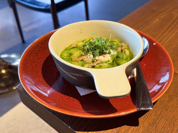 Pasta in a white bowl atop a red plate is served at the restaurant at Cathay Pacific's airport lounge in Hong Kong.