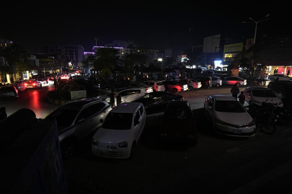 A car drive in a market, where some shopkeeper are using generators for electricity during a national-wide power breakdown, in Islamabad, Pakistan, Monday, Jan. 23, 2023. Much of Pakistan was left without power Monday as an energy-saving measure by the government backfired. The outage spread panic and raised questions about the cash-strapped government's handling of the country's economic crisis. (AP Photo/Anjum Naveed)