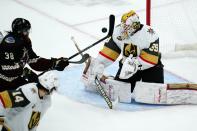 Vegas Golden Knights goalie Laurent Brossoit (39) makes a save on a shot as Arizona Coyotes center Liam O'Brien (38) is unable to get a stick on the puck and Golden Knights defenseman Nicolas Hague (14) watches during the third period of an NHL hockey game Friday, Dec. 3, 2021, in Glendale, Ariz. The Golden Knights won 7-1. (AP Photo/Ross D. Franklin)