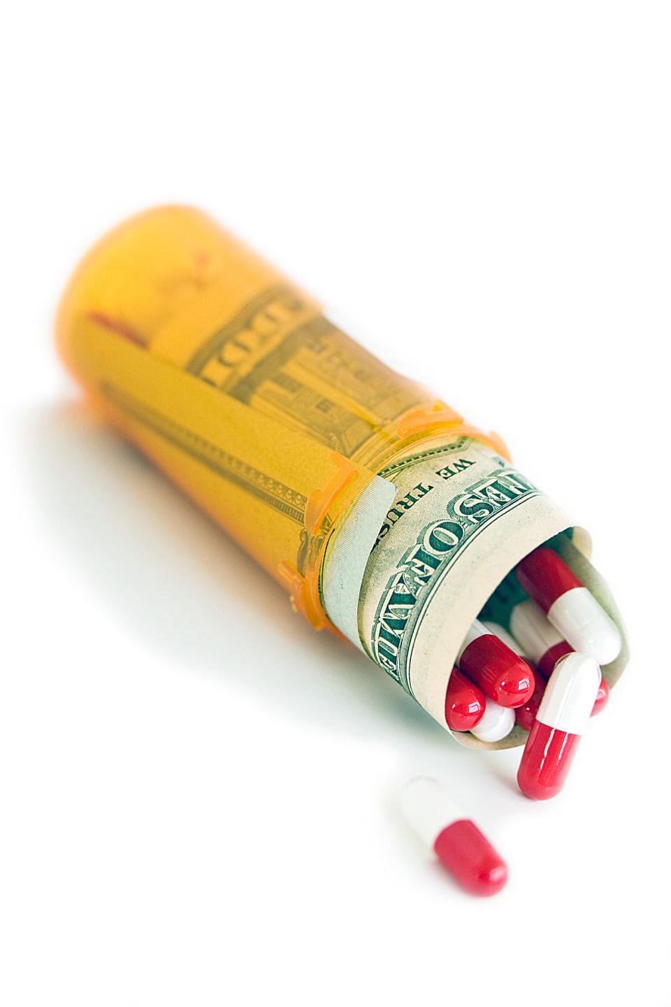 Money and pills in medicine bottle