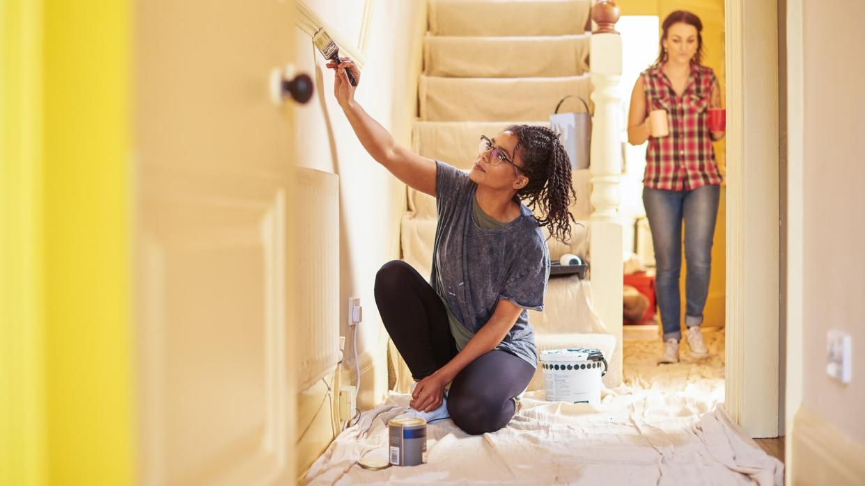 two women renovating their home giving it a fresh coat of paint