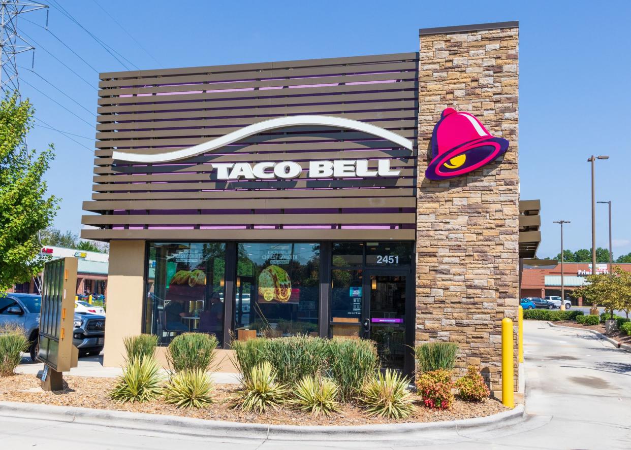 Hickory, USA-9/2/18: The front exterior of a Taco Bell restaurant in Hickory, NC, showing the drive-thru, and one pickup truck parked to the left.  A male-female couple are visible thru the left front window.