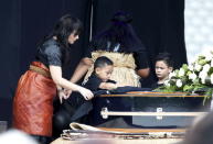 Former All Black Jonah Lomu's widow Nadene Lomu and her two sons, Brayley Lomu and Dhyreille (L) Lomu drape a flag over Jonah's casket in Eden Park for his memorial service in Auckland, November 30, 2015. REUTERS/Nigel Marple