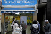 People queue at a bureau de change in London, Tuesday, Sept. 27, 2022. The British pound has stabilized in Asian trading after plunging to a record low, as the Bank of England and the British government try to soothe markets nervous about a volatile U.K. economy. The instability is having real-world impacts, with several British mortgage lenders withdrawing deals amid concern that interest rates may soon rise sharply. (AP Photo/Frank Augstein)