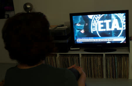 A woman watches a news program announcing the dissolution of armed Basque separatists ETA due for the first week of May, according to local television station ETB, in Guernica, April 18, 2018. REUTERS/Vincent West