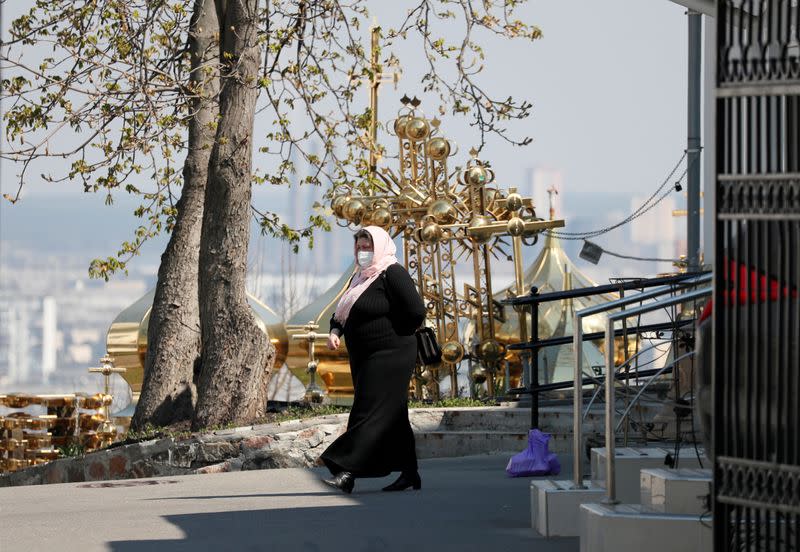 FILE PHOTO: A woman wearing a protective face mask walks in the territory of the Kiev Pechersk Lavra monastery in Kiev