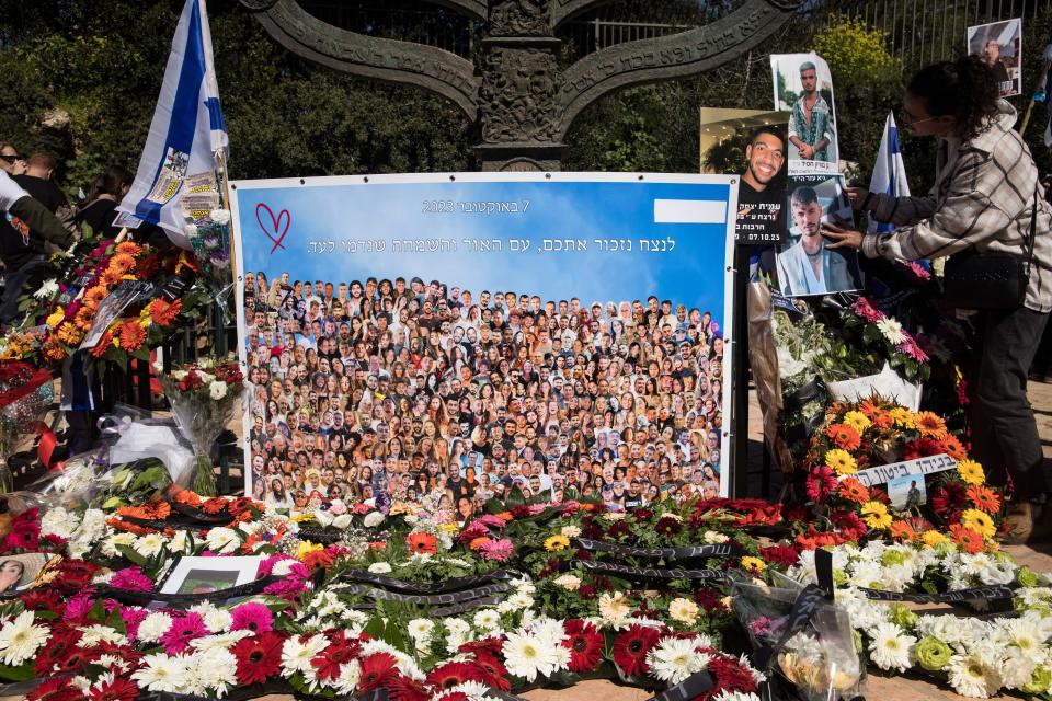 A woman hangs a photo of a man, killed during the Oct. 7 deadly Hamas attack, during a memorial event in Jerusalem on Feb. 7, 2024. The event marked four months since the war began.