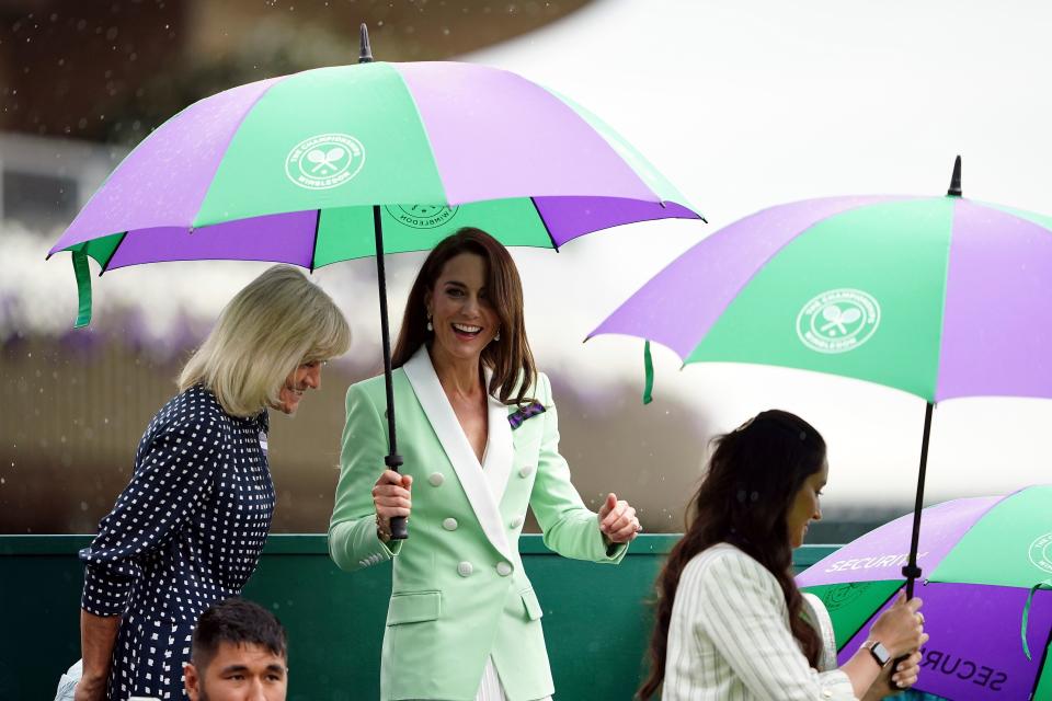 比賽一度因大雨中斷，不過並未澆熄運動迷凱特的熱情。（AP）