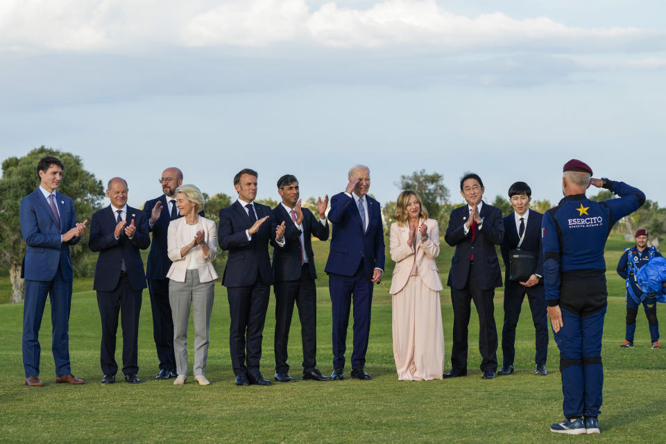 From left, Canada's Prime Minister Justin Trudeau, German Chancellor Olaf Scholz, European Council President Charles Michel, European Commission President Ursula von der Leyen, French President Emmanuel Macron, Britain's Prime Minister Rishi Sunak, U.S. President Joe Biden, Italian Prime Minister Giorgia Meloni, and Japan's Prime Minister Fumio Kishida applaud and salute to an Italian Army parachuter after watching a skydiving demo during the G7 world leaders summit at Borgo Egnazia, Italy, Thursday, June 13, 2024. (AP Photo/Domenico Stinellis)