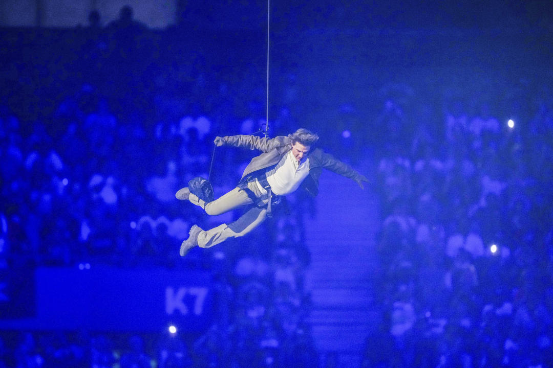 Tom Cruise is lowered on the State de France during the 2024 Summer Olympics closing ceremony, Sunday, Aug. 11, 2024, in Saint-Denis, France. (AP Photo/Natacha Pisarenko)