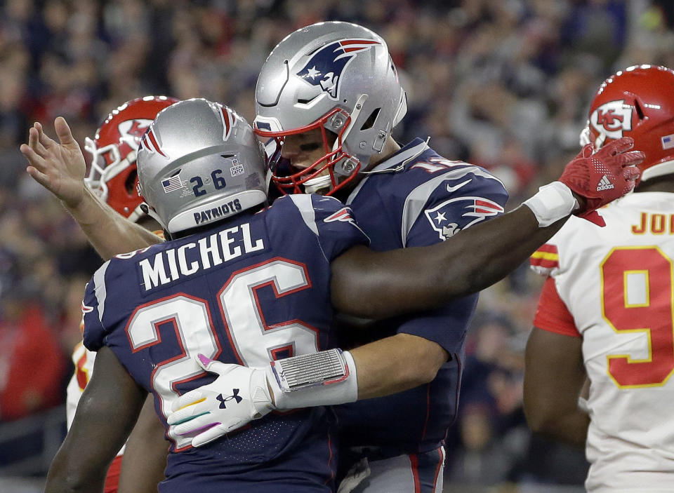 New England Patriots quarterback Tom Brady, right, celebrates a rushing touchdown by running back Sony Michel (26) during the first half of an NFL football game against the Kansas City Chiefs, Sunday, Oct. 14, 2018, in Foxborough, Mass. (AP Photo/Steven Senne)