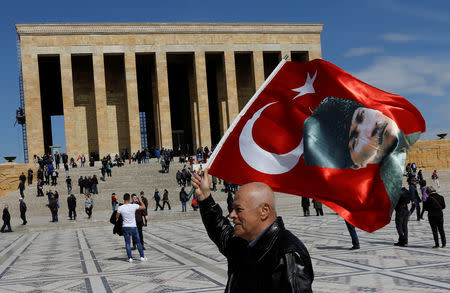 A man waves a Turkish flag with a portrait of modern Turkey's founder Mustafa Kemal Ataturk as he visits Anitkabir, the mausoleum of Ataturk, in Ankara, Turkey, April 2, 2019. REUTERS/Umit Bektas