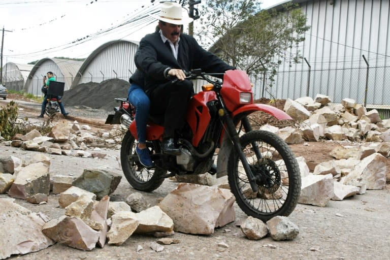 Former Honduran President Manuel Zelaya, ousted in a 2009 coup, rides a motorcycle through the blocked streets and avenues of Tegucigalpa