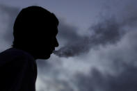 A young man smokes a Suorin Drop electronic cigarette in this picture illustration taken September 14, 2018. REUTERS/Mike Blake/Illustration