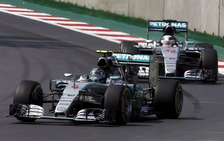 Mercedes Formula One drivers Nico Rosberg (L) of Germany and Lewis Hamilton (44) of Britain go into a turn together during the Mexican F1 Grand Prix at Autodromo Hermanos Rodriguez in Mexico City, November 1, 2015. REUTERS/Henry Romero