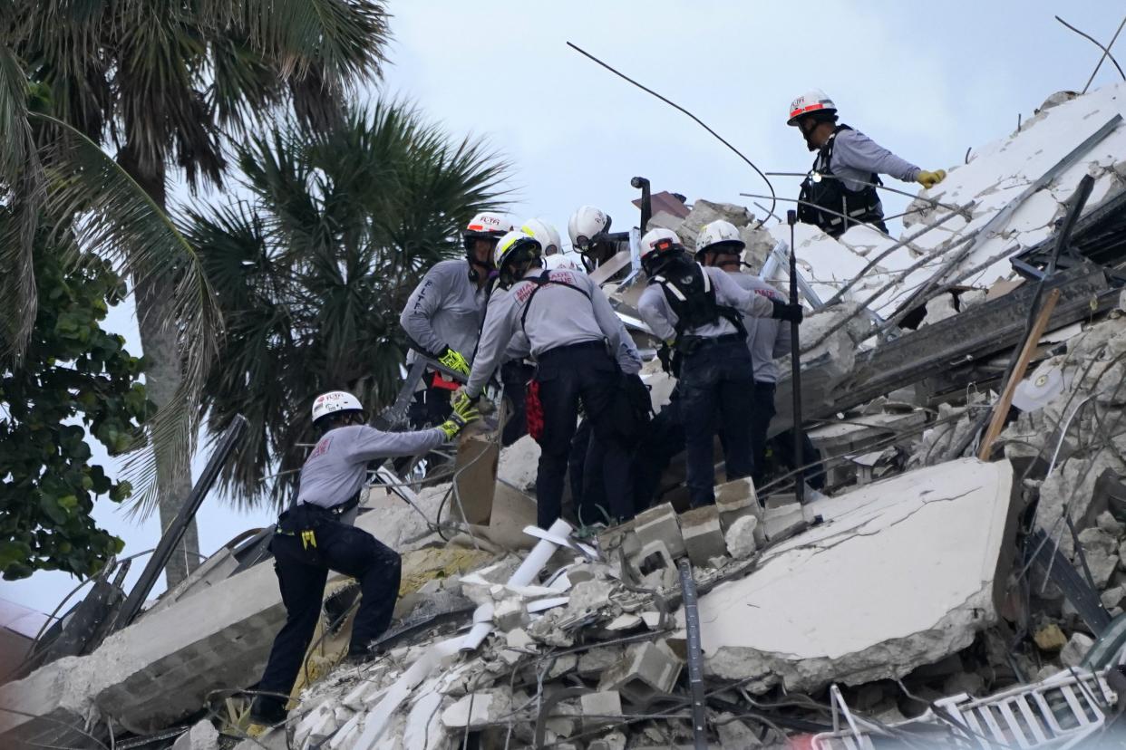 Rescue workers look through the rubble where a wing of a 12-story beachfront condo building collapsed, Thursday, June 24, 2021, in the Surfside area of Miami. (AP Photo/Lynne Sladky)