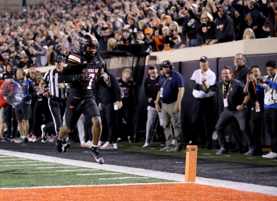Oklahoma State's Cameron Epps (7) returns an interception for a touchdown in the first half of Friday's game against Kansas State in Stillwater.