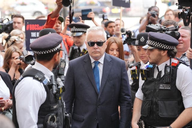 Huw Edwards surrounded by police officers