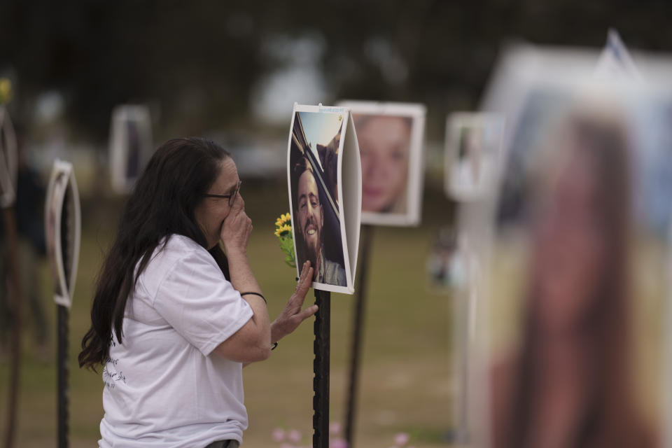 Ela Bahat touches a picture of her 30-year-old son Dror, who was killed on Oct. 7 in a cross-border attack by Hamas at the Nova music festival in Re'im, southern Israel, Sunday, Jan. 21, 2024, during an event where friends and relatives are planting trees in memory of their loved ones. (AP Photo/Leo Correa)