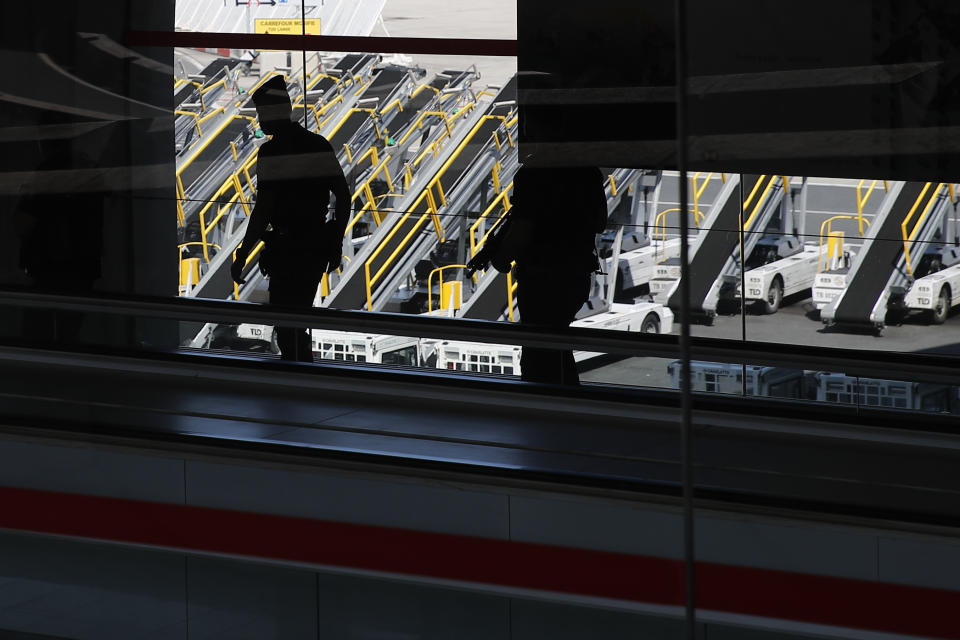 French police officers patrol in the access corridors in Roissy airport, north of Paris, Tuesday, May 12, 2020. France is cautiously easing the two-month lockdown across the country. Specific measures, such as more widely spaced stalls, have been implemented to enforce physical distancing. (AP Photo/Francois Mori)