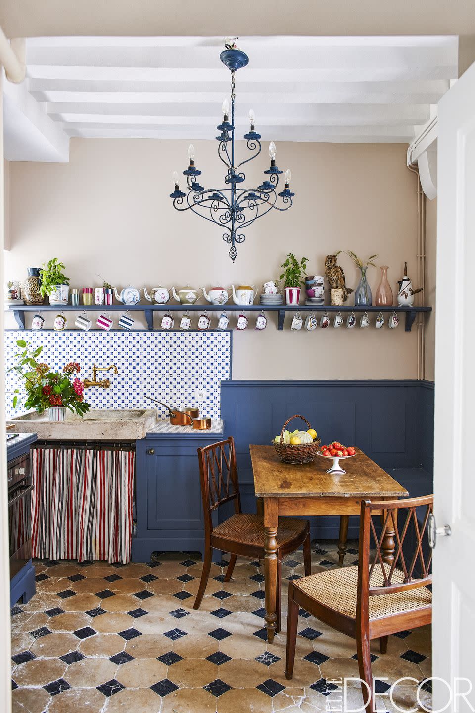<p>The homeowners kept the original tile backsplash and flooring in the kitchen of this Loire Valley home. <a href="https://www.elledecor.com/design-decorate/house-interiors/a9396/english-estate/" rel="nofollow noopener" target="_blank" data-ylk="slk:English;elm:context_link;itc:0;sec:content-canvas" class="link ">English</a> mahogany chairs and a <a href="https://www.elledecor.com/shopping/g3457/best-modern-chandeliers/" rel="nofollow noopener" target="_blank" data-ylk="slk:stylish chandelier;elm:context_link;itc:0;sec:content-canvas" class="link ">stylish chandelier</a>, which was found at a flea market, give the space a lived-in feel.<br></p>