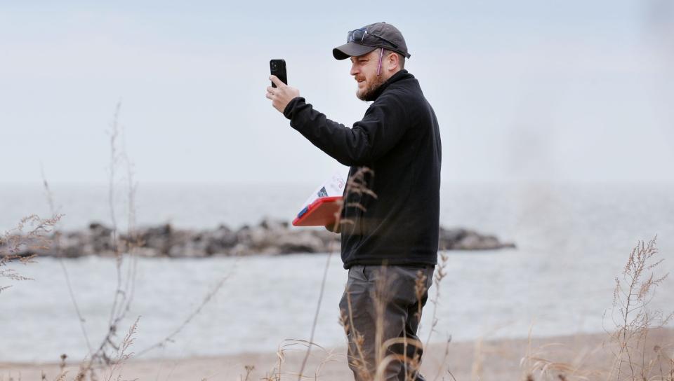 Weston Cross, with the U.S. Army Corps of Engineers takes photos and notes during the spring 2024 beach walk at Presque Isle State Park.