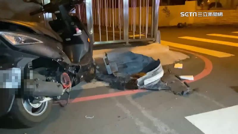 一台機車雙載經過路口時遭轎車撞擊，車殼、零件散落一地。