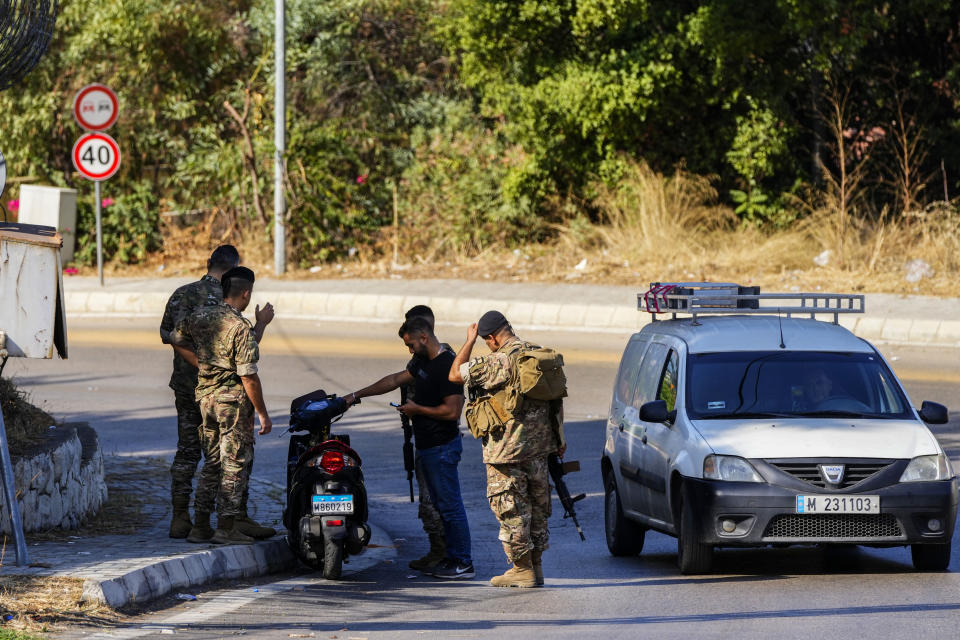 Lebanese soldiers check a driver motorcycle document as investigators collect forensic evidence outside U.S. Embassy in Aukar, a northern suburb of Beirut, Lebanon, Thursday, Sept. 21, 2023. Lebanon's security agencies have launched an investigation into a late night shooting outside the U.S. embassy in Lebanon that caused no injuries, officials said Thursday. (AP Photo/Hassan Ammar)