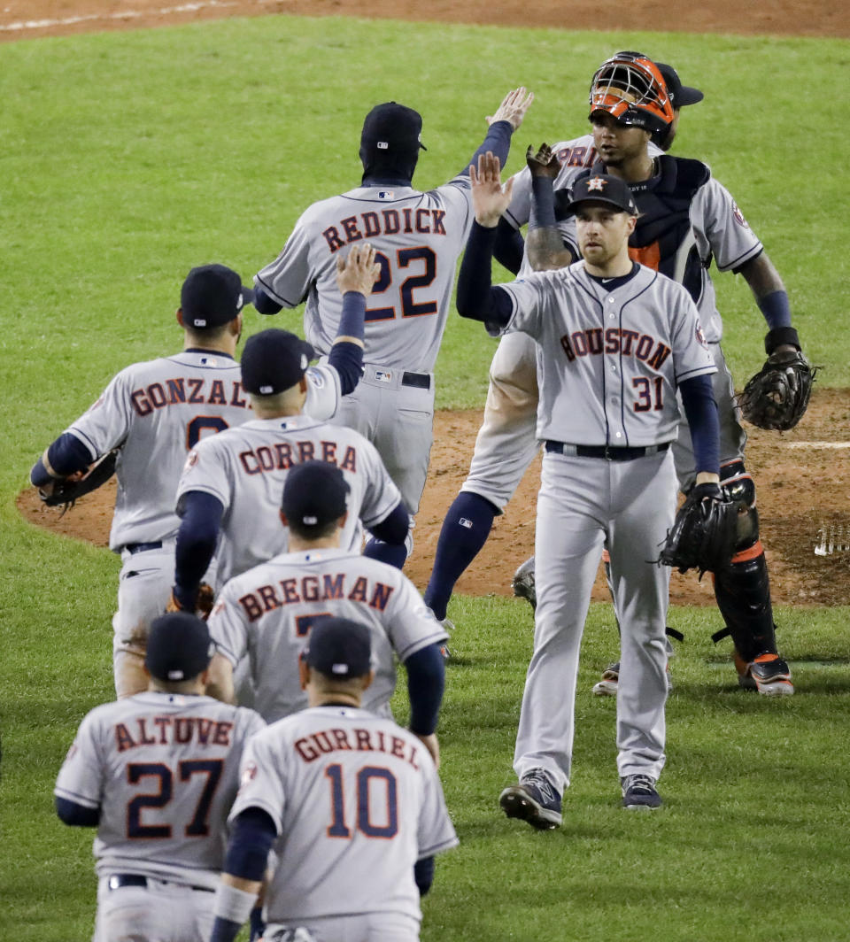 The Houston Astros celebrate their win against the Boston Red Sox in Game 1 of a baseball American League Championship Series on Saturday, Oct. 13, 2018, in Boston. The Astros won 7-2. (AP Photo/Elise Amendola)