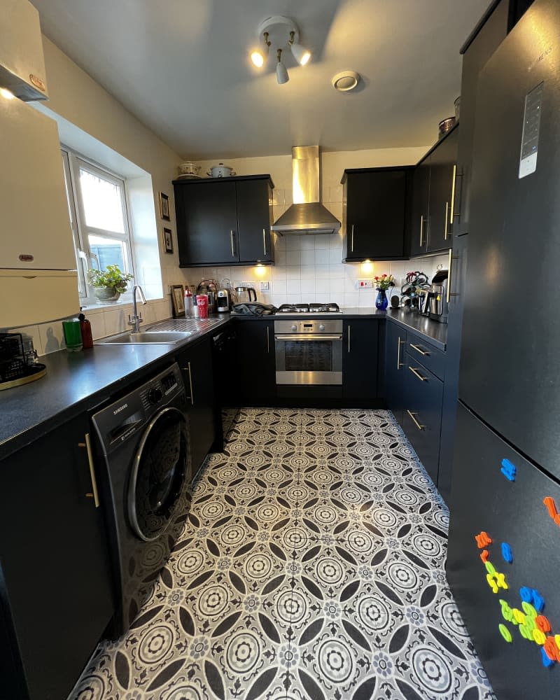 White kitchen with black cabinets and black and white floor after remodel