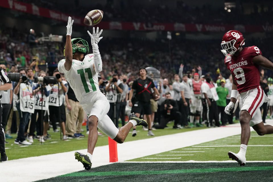 Oregon wide receiver Troy Franklin (11) makes a touchdown catch in front of Oklahoma cornerback D.J. Graham (9) during the second half of the Alamo Bowl NCAA college football game Wednesday, Dec. 29, 2021, in San Antonio. (AP Photo/Eric Gay)