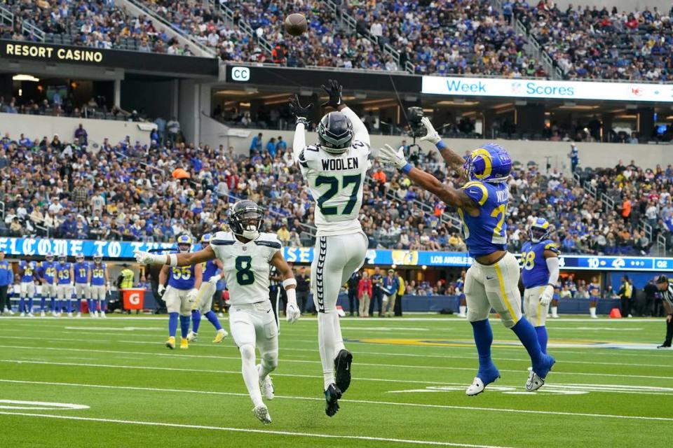 Seattle Seahawks cornerback Tariq Woolen (27) intercepts a pass intended for Los Angeles Rams running back Kyren Williams, right, as Seahawks cornerback Coby Bryant (8) watches during the first half of an NFL football game Sunday, Dec. 4, 2022, in Inglewood, Calif. (AP Photo/Marcio Jose Sanchez)