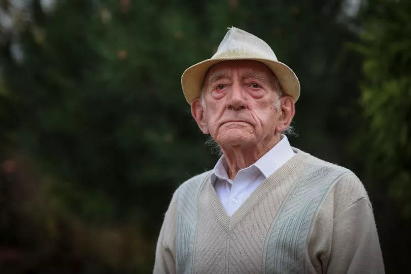 World War Two veteran, Norman Powell, 98, pictured at home in Toton, Nottingham. He is wearing a V neck sweater with a white shirt and a hat.