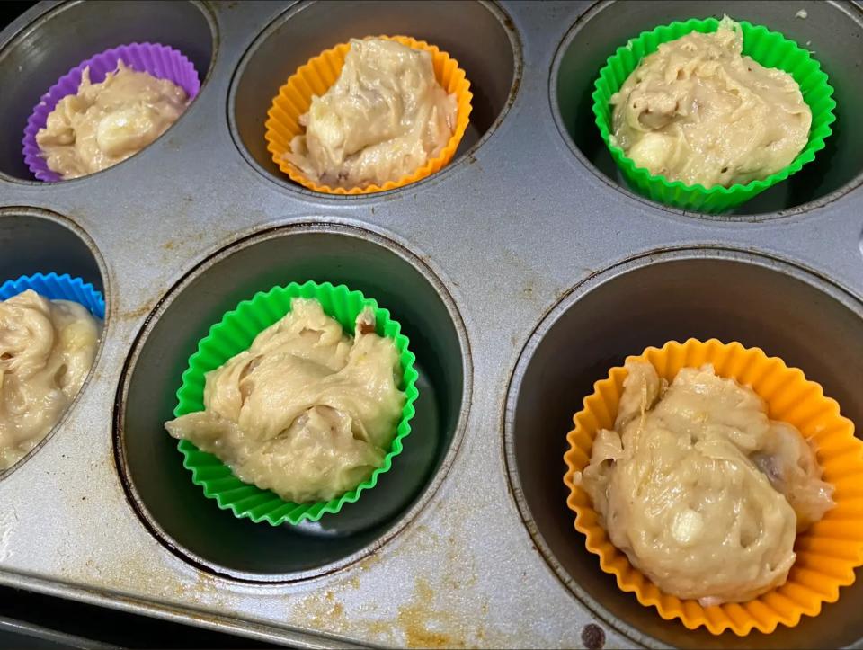 Banana-muffin batter in cupcake liners in a muffin pan.