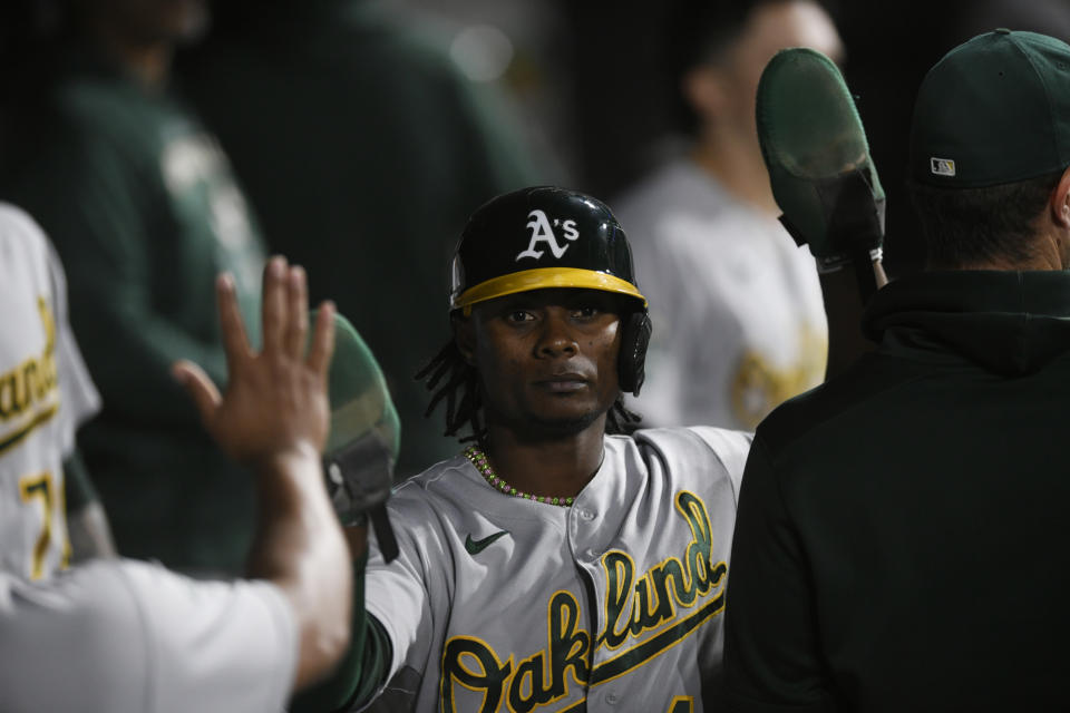 Oakland Athletics' Esteury Ruiz celebrates with teammates in the dugout after scoring on fielder's choice hit into by Carlos Perez during the eighth inning of a baseball game against the Chicago White Sox, Saturday, Aug. 26, 2023, in Chicago. (AP Photo/Paul Beaty)