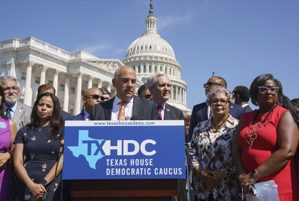 Rep. Chris Turner, chairman of the Texas House Democratic Caucus, center, is joined by Democratic members of the Texas legislature at a news conference at the Capitol in Washington, Tuesday, July 13, 2021, after they left Austin hope to deprive the Legislature of a quorum — the minimum number of representatives who have to be present for the body to operate. They are trying to kill a Republican bill making it harder to vote in the Lone Star State. (AP Photo/J. Scott Applewhite)