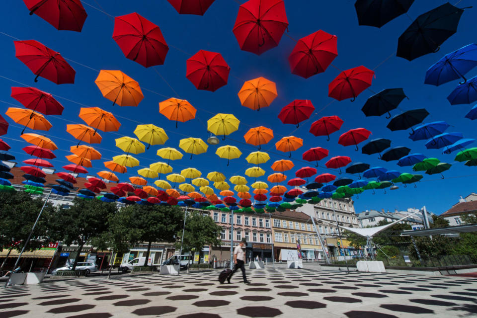 <p>A man walks under spectral colored umbrellas of the art installation ‘REGEN.WALD’ (rain.forest) in Vienna, Austria, Aug. 31, 2016. The installation is part of the annual cultural projects 'space and place’ and 'Vienna lives’. (Photo: CHRISTIAN BRUNA/EPA)</p>