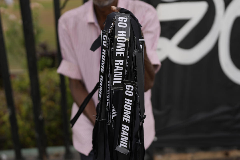 A man sells hand bands which read "Ranil Go home" referring to Prime Minister Ranil Wickremesinghe at a protest site in Colombo, Sri Lanka, July 17, 2022. Bankruptcy has forced the island nation's government to a near standstill. Parliament is expected to elect a new leader Wednesday, paving the way for a fresh government, but it is unclear if that's enough to fix a shattered economy and placate a furious nation of 22 million that has grown disillusioned with politicians of all stripes. (AP Photo/Rafiq Maqbool)