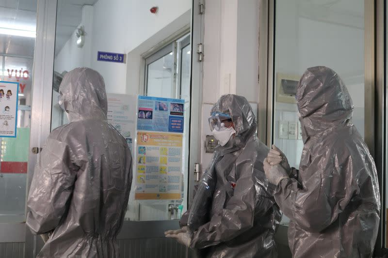 Doctors wearing protective suits walk to an isolated section at Cho Ray hospital in Ho Chi Minh city