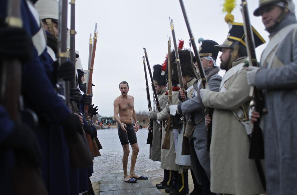A man walks as he crossed Berezina river after the re-enactment battle in the town of Borisov, 70 km (44 miles) east of Minsk, Belarus, Saturday, Nov. 23, 2019, to mark the 207th anniversary of the Berezina battle during Napoleon's army retreat from Russia. (AP Photo/Sergei Grits)
