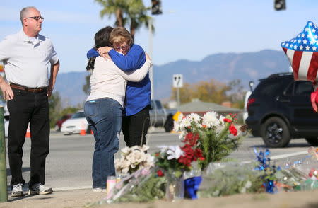 Mourners gather around a makeshift memorial in honor of victims following Wednesday's attack in San Bernardino, California December 5, 2015. REUTERS/Sandy Huffaker