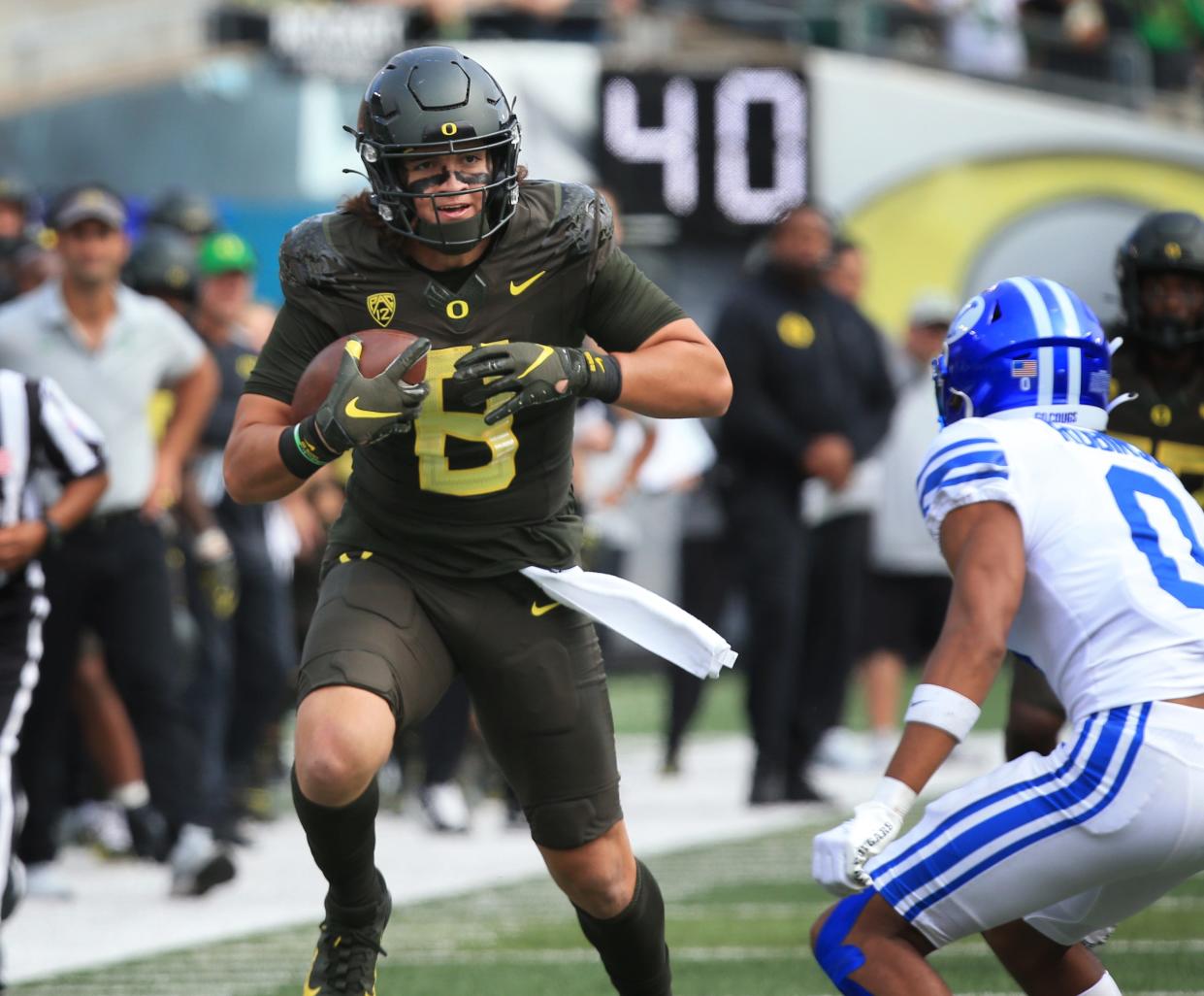 Oregon's Moliki Matavao, left, runs the ball against BYU during the third quarter at Autzen Stadium in September 2022.