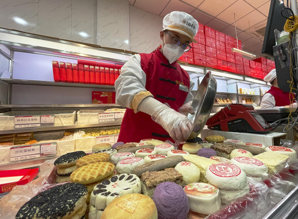 A worker packs a new year gift box with traditional pastries at a branch of Daoxiangcun, one of the best-known Chinese bakeries in Beijing, China, on Jan. 14, 2023. (AP Photo/Caroline Chen)