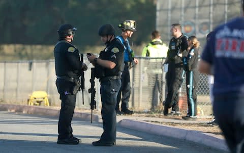 Emergency personnel stand outside Gilroy High School - Credit: AP