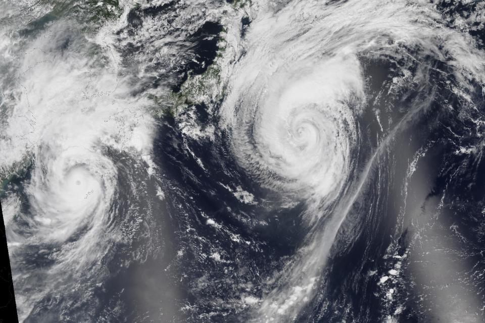 This natural-color image mosaic, provided by NASA, taken in Aug. 2015, based on data collected during two orbital passes of the Visible Infrared Imaging Radiometer Suite (VIIRS) shows typhoons in the western North Pacific. A new scientific report finds man-made climate change played some kind of role in two dozen extreme weather events around the world in 2015. But it also detected no global warming fingerprints in a handful of other weird weather instances. (NASA via AP)