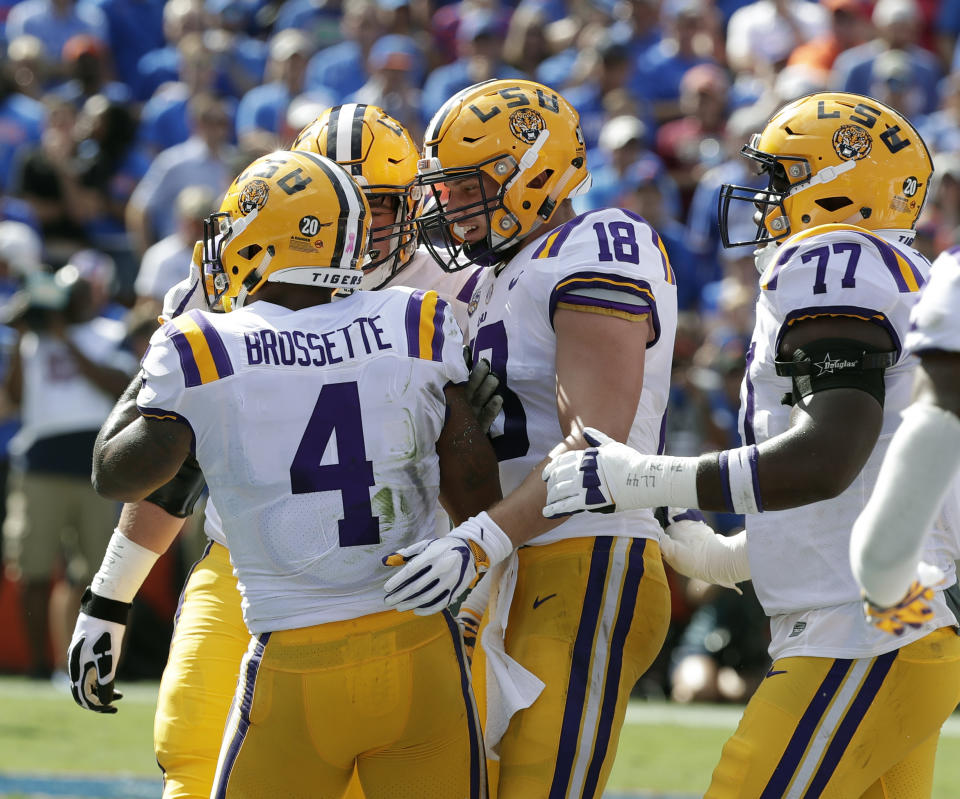 LSU players, including tight end Foster Moreau (18) and offensive tackle Saahdiq Charles (77) celebrate with running back Nick Brossette (4) after he scored a touchdown against Florida on a 4-yard run durinng the first half of an NCAA college football game, Saturday, Oct. 6, 2018, in Gainesville, Fla. (AP Photo/John Raoux)