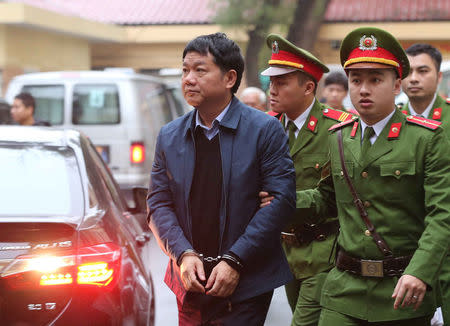 Vietnam's former Communist Party Politburo member and former chairman of PetroVietnam Dinh La Thang (L) is escorted by police to the court in Hanoi, Vietnam January 8, 2018. Mandatory credit VNA/Doan Tan via REUTERS
