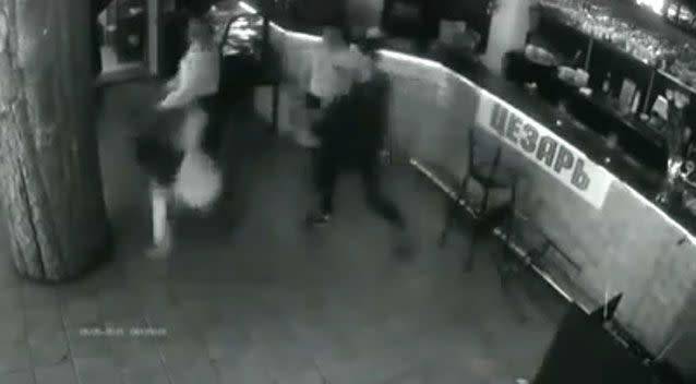 The outraged waitress takes one final swipe, hitting the customer to the floor with a menu. Photo: YouTube screen shot