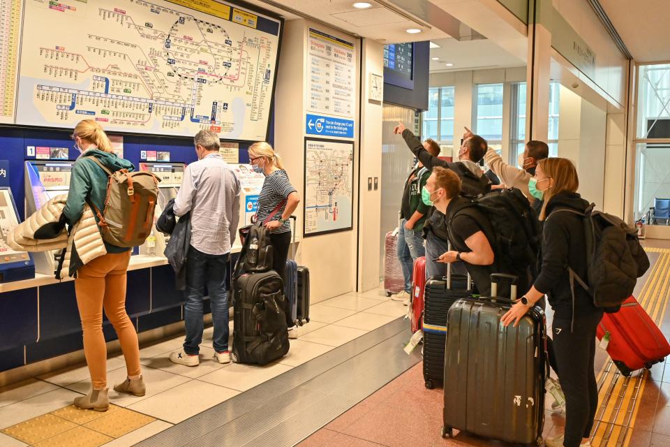 People look at the rail map as they buy tickets into the city after their arrival at the international terminal of Tokyo's Haneda Airport on October 11, 2022, as Japan reopened to foreign travellers after two-and-a-half years of Covid restrictions. (Photo by Richard A. Brooks / AFP) (Photo by RICHARD A. BROOKS/AFP via Getty Images)