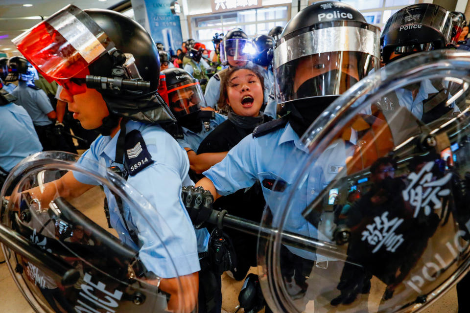 Riot police detain a woman as anti-government protesters gather at Sha Tin Mass Transit Railway (MTR) station to demonstrate against the railway operator, which they accuse of helping the government, in Hong Kong, China, September 25, 2019.